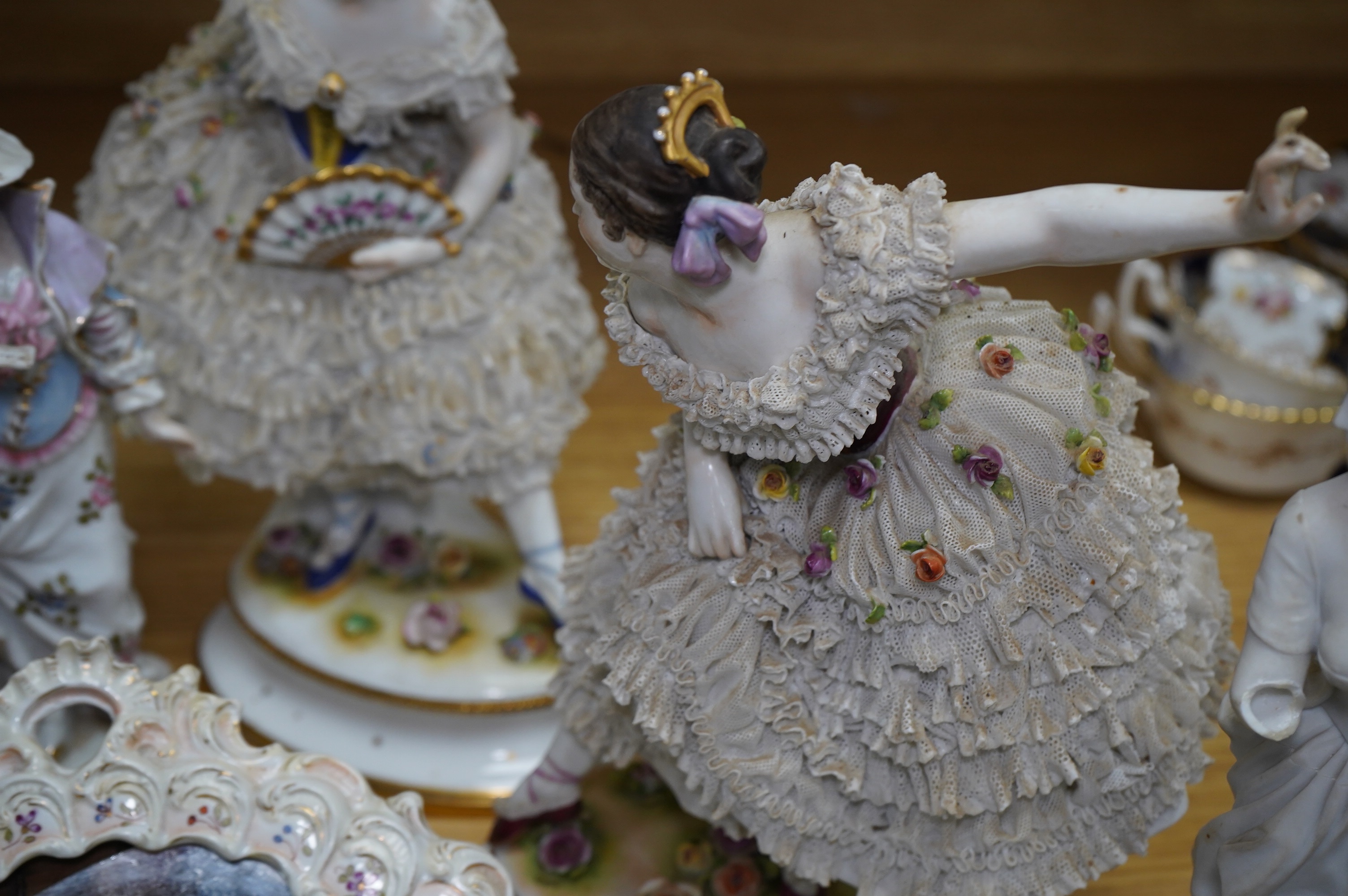 A collection of Continental porcelain ceramic figurines, including a pair of lace examples, dancing ladies and an easel mirror, largest 29cm high. Condition - mostly poor